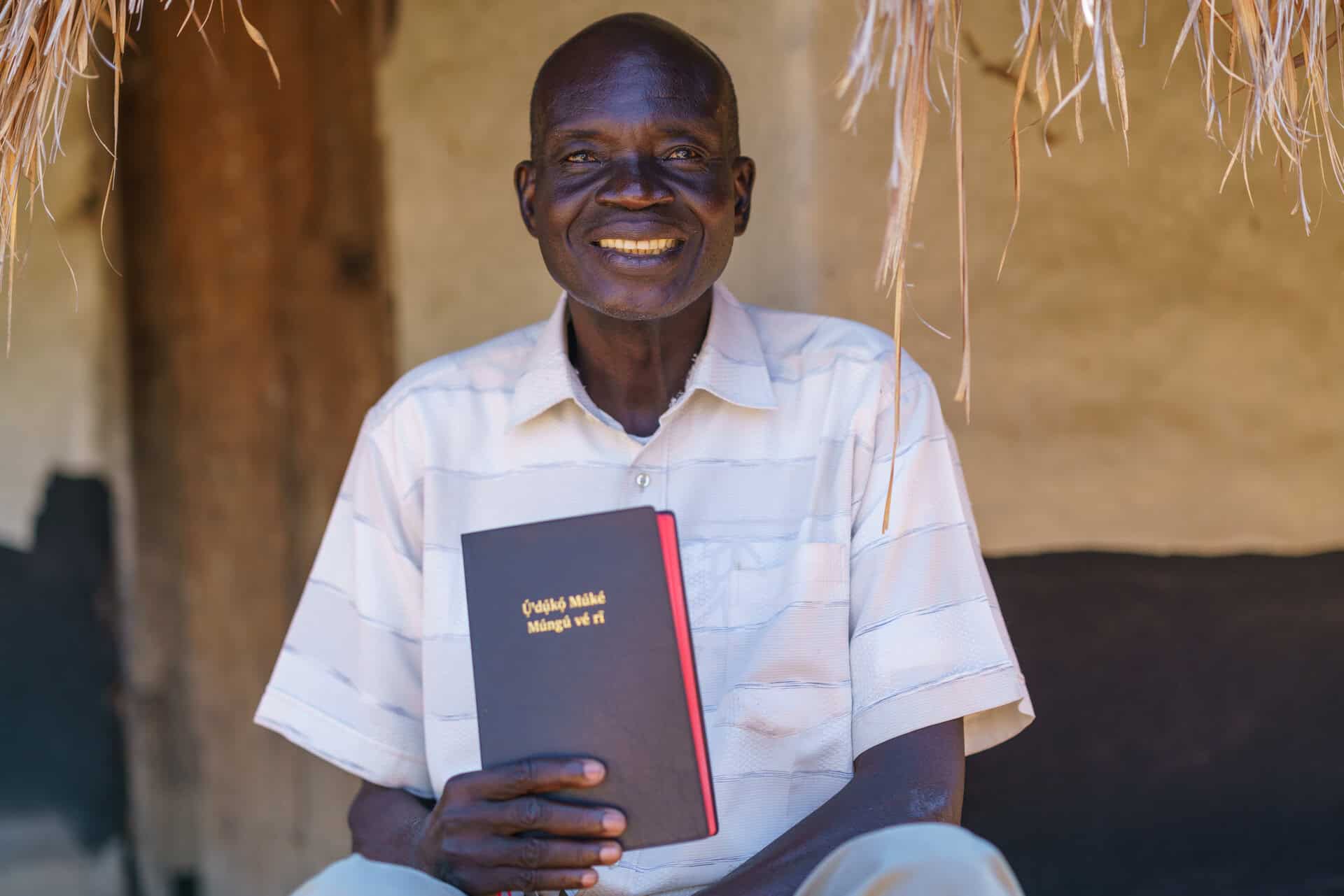 The Keliko people are from South Sudan.  Although Bible translation started in 1985, decades of civil war forced translators to postpone their work.  Many Keliko fled to Northern Uganda - the location where the Keliko NT was eventually completed.  Decades after translation began, on 11 August 2018, the Keliko New Testament was dedicated, and now for the first time the Keliko people can hear God’s Word in their own language.
Here, Keliko NT translator Isaac Kenyi holds the Keliko New Testament.